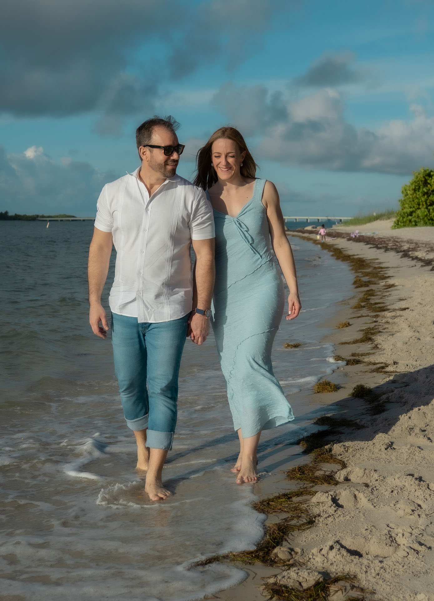 Ingrid and Miguel walking along the beach smiling