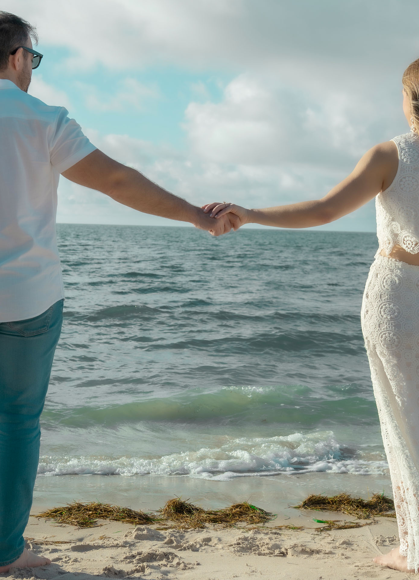 Ingrid and Miguel holding hands looking at the ocean