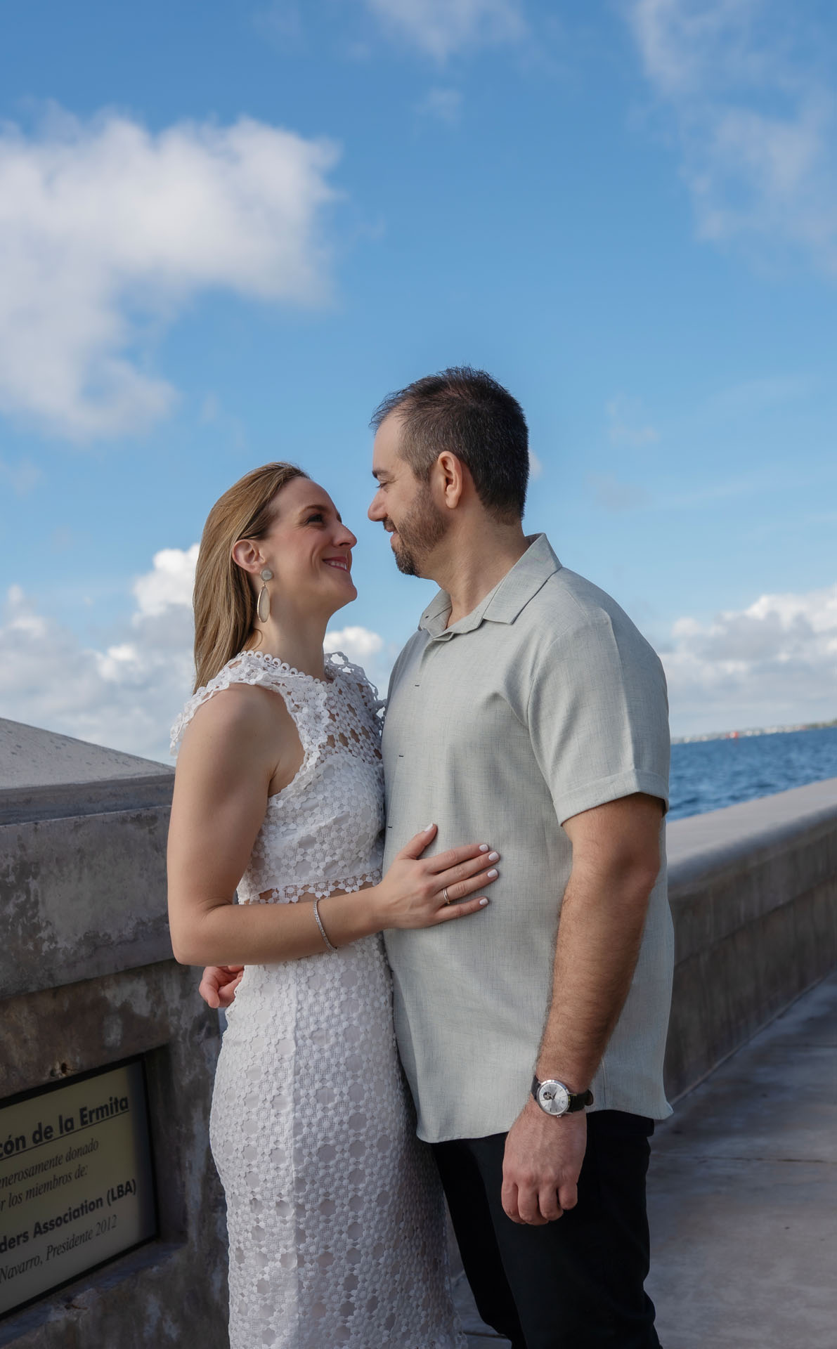 Ingrid and Miguel embracing by the seawall